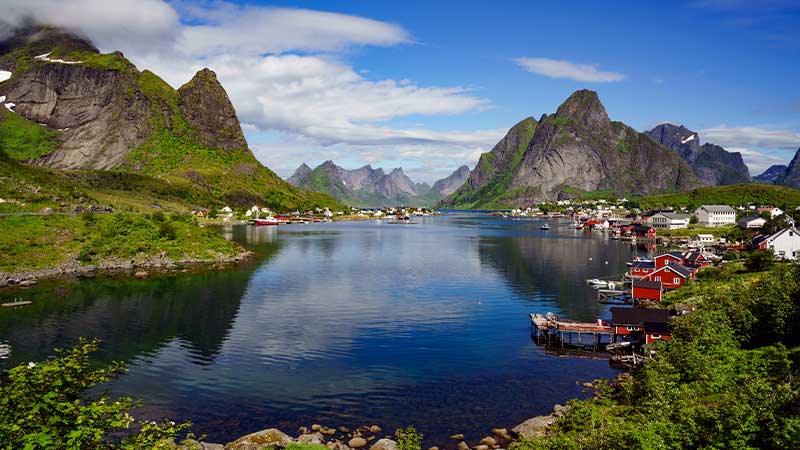 Upplev Lofotens fiskehamn med röda sjöbodar vid bukten – dramatiska fjäll i bakgrunden på resan med Tjörnapsbuss