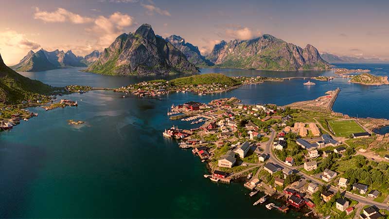 Utsikt över Tromsø hamn – färgglada byggnader, båtar och fjäll i bakgrunden under arktisk himmel