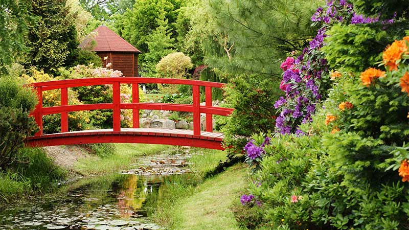 Röd bro i Hortulus Garden. Upplev den under bussresan med Tjörnarpsbuss i Pommern