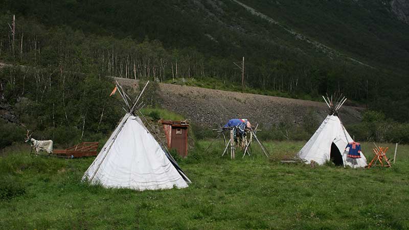 Ett samiskt läger med traditionella kåtor omgivna av fjällnatur under Tjörnarpsbuss nordkapsresa