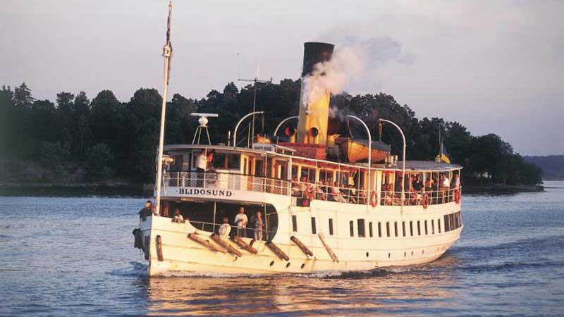 Båtkryssning i Stockholms skärgård på solglittrande vatten förbi vackra öar.
